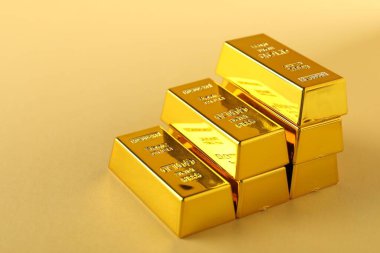 Bej arka planda parlak altın külçeler, yakın plan. Metin için boşluk