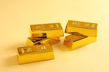 Bej arkaplanda parlak altın çubuklar, yakın plan