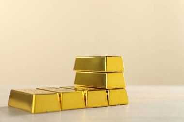 Bej arka planda parlak altın külçeler, yakın plan. Metin için boşluk