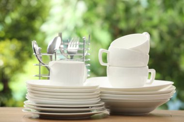 Farklı temiz bulaşık takımları, bardaklar ve çatal bıçak sehpası.