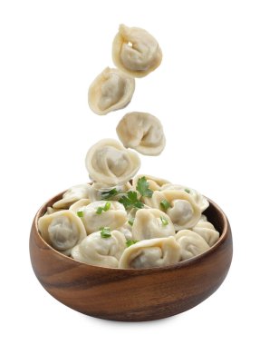 Lezzetli haşlanmış hamur tatlısı (pelmeni) beyaz arka planda kaseye düşüyor