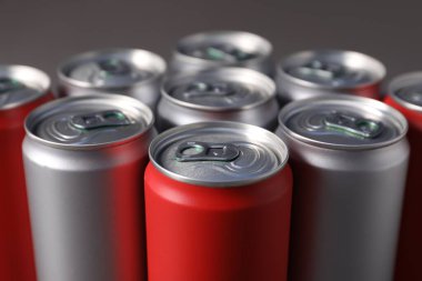 Gri arka planda birçok alüminyum içecek kutusu, yakın plan