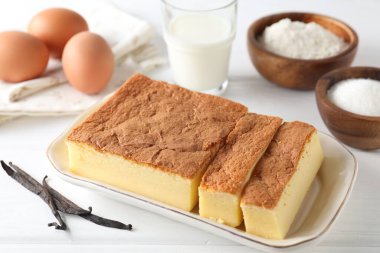 Lezzetli Japon Castella sünger keki ve malzemeler beyaz masada, yakın plan.