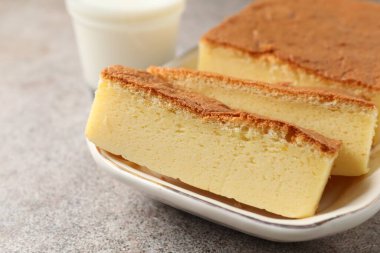 Lezzetli Japon Castella sünger kek ve süt ışık masasında, yakın çekim