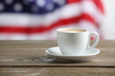 Amerikan bayrağına karşı ahşap masada fincanda Aromatik kahve, metin için yer