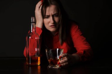 Alkol bağımlılığı. Karanlıkta viski içen sefil kadın.