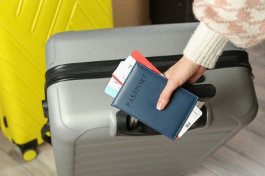 Pasaportlu kadın, biletler ve bavullar içeride, yakın plan.