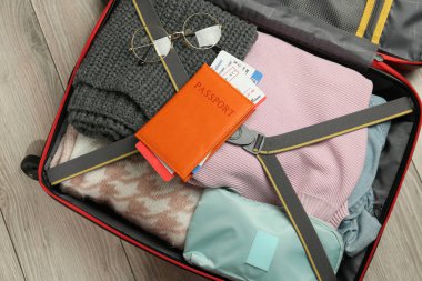 Bilet ve gözlüklü pasaport paketlenmiş bavul, üst manzara.