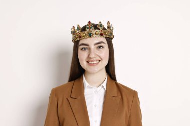 Mutlu iş kadını, parlak arkaplanda zarif bir taç giyiyor.