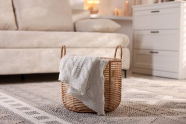 Kapalı yerde örülmüş battaniyeli hasır sepet.