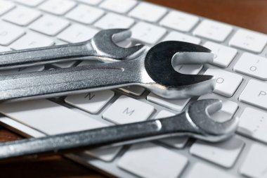 Teknik destek konsepti. Ahşap arkaplanda anahtarlar ve klavye, yakın plan