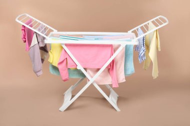 Bej arka planda temiz çamaşırlı kuru askı.