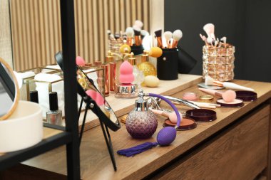 Makyaj odası. Ayna ve ahşap tuvalet masasındaki farklı güzellik ürünleri.