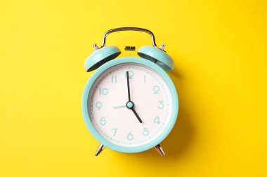 Sarı arka planda turkuaz alarm saati, üst görünüm