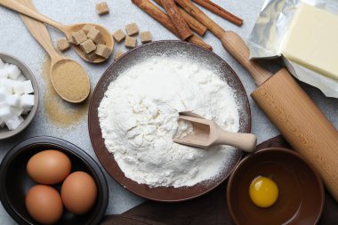 Hamur için merdane ve malzemeler açık gri masada, düz yatıyordu.