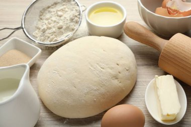 Yuvarlanan iğne ve farklı malzemeler açık ahşap masada, yakın plan.