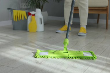 Yerleri mikrofiber paspasla temizleyen kadın, yakın plan.