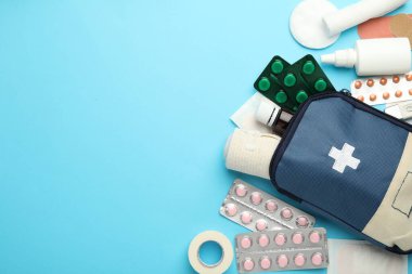 Açık mavi arkaplan üzerine ilk yardım çantasıyla düz konum, metin için boşluk