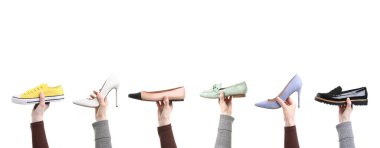 Beyaz arka planda farklı ayakkabılar tutan insanlar, yakın plan.