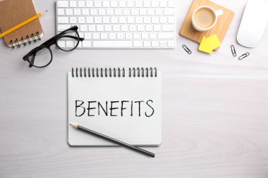 Not defteri, kalem, gözlük, bilgisayar klavyesi ve fareyi beyaz ahşap masada, üst görünümde yararlandırır