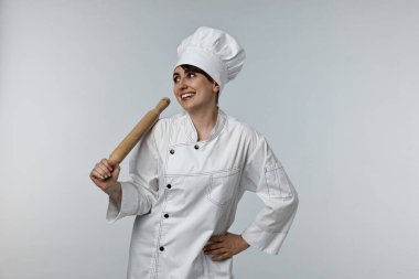 Açık gri arka planda merdanesi olan profesyonel şef.