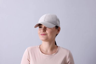 Beyzbol şapkalı, gri arka planda bir kadın. Tasarım için model