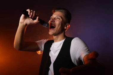 Esmer arka planda şarkı söyleyen yetenekli genç adam.