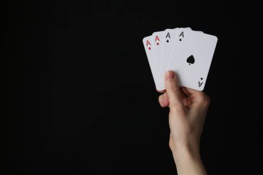 Siyah arka planda iskambil oynayan kadın, yakın plan. Metin için boşluk