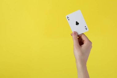 Sarı arka plana karşı iskambil oynayan kadın, yakın plan. Metin için boşluk