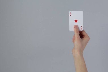 Gri arka planda kart oynayan kadın, yakın plan. Metin için boşluk