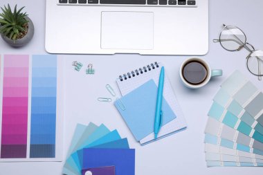 Kırtasiyeci işyeri, renk paletleri, kahve ve dizüstü bilgisayarı gri masada, düz yatıyordu.