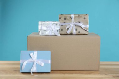 Açık mavi arkaplan ile ahşap masa üzerinde hediye kutuları ile paket