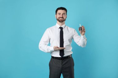 Açık mavi arka planda araba anahtarı olan neşeli bir satıcı.