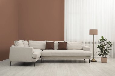 Mocha mus gölgesinde elementleri olan şık bir oturma odası. 2025 'in moda rengine sahip iç tasarım