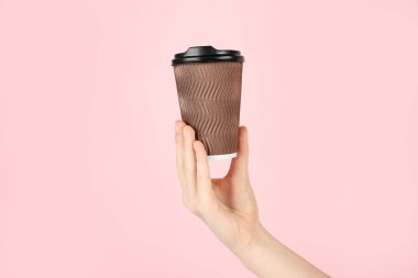 Pembe arka planda kağıt bardak tutan kadın, yakın plan. Tasarım için model