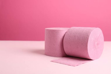 Pembe arka planda renkli tuvalet kağıdı ruloları. Metin için boşluk
