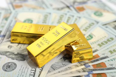 Parlak altın külçeler dolar banknotları, yakın plan