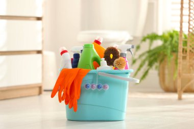 Banyoda yerde farklı temizlik malzemeleriyle dolu bir kova.