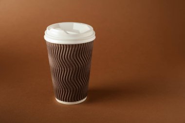 Kahverengi arka planda bir kağıt bardak. Tasarım için model