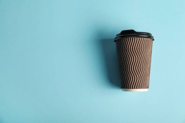 Açık mavi arka planda kağıt bardak, üst manzara. Tasarım için model