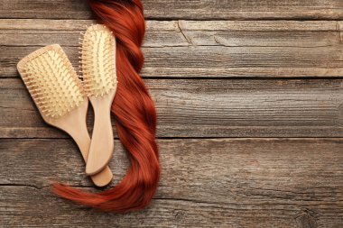 Fırçalar ve bir tutam saç ahşap masada, düz yerde. Metin için boşluk