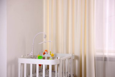 Odada beşiği olan şirin bir bebek arabası.