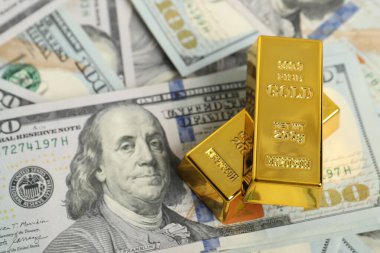 Dolar banknotları üzerinde parlak altın külçeler, manzaranın üstünde. Metin için boşluk