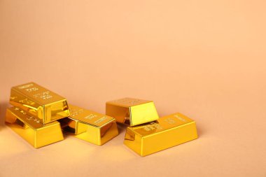 Açık mercan zemin üzerinde parlak altın külçeler, yakın plan. Metin için boşluk