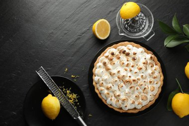 Lezzetli kremalı turta, limon, rende ve sıkma makinesi siyah desenli masa, düz uzanma