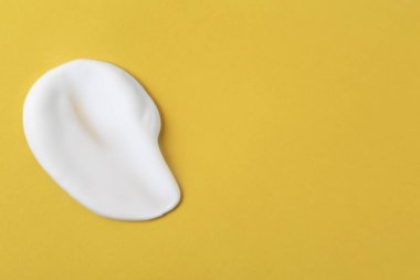 Sample of fluffy foam on orange background, top view. Space for text