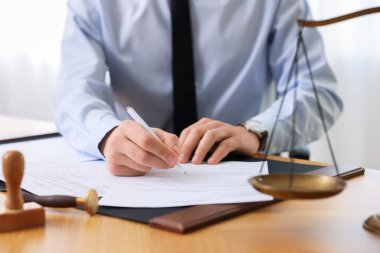 Ofisteki ahşap masada noter imzalı belge, yakın plan.