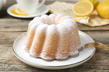 Tahta masaya pudra şekerli lezzetli limonlu pasta, yakın plan.