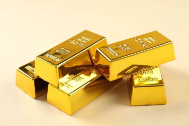 Bej arkaplanda parlak altın çubuklar, yakın plan