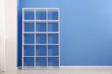 İçerideki mavi duvarın yanındaki boş raf ünitesi. Metin için boşluk